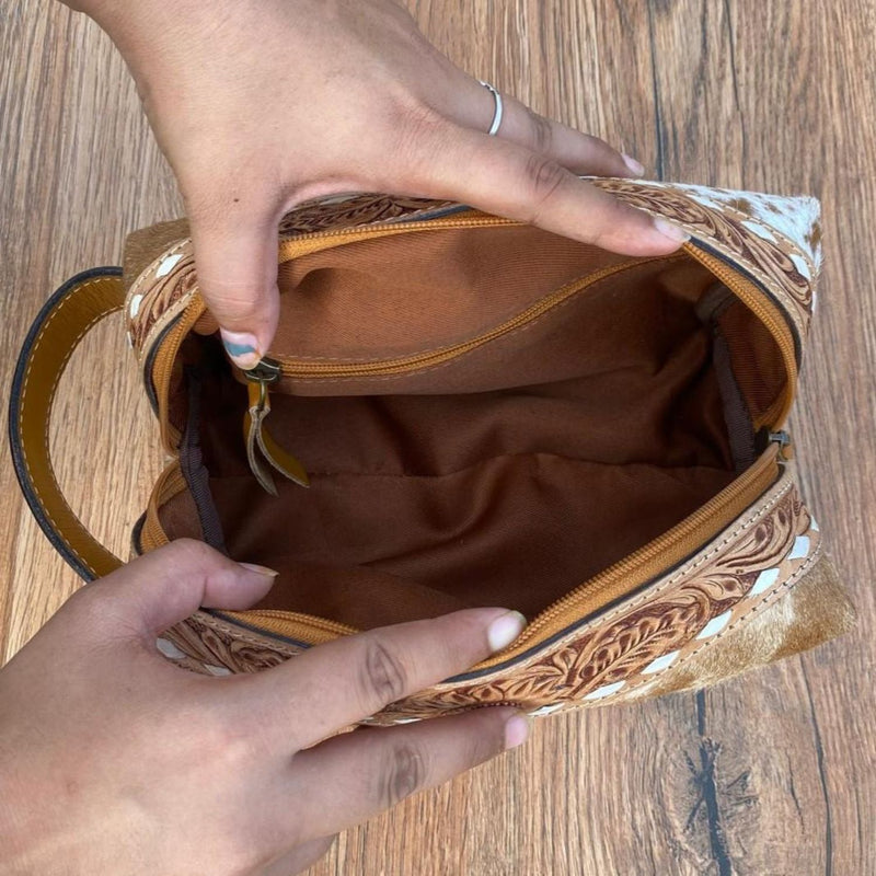 Interior view of the Golden Cowhide Western Luxe Leather Toiletry Bag, showcasing the spacious compartment and secure zipper pocket.