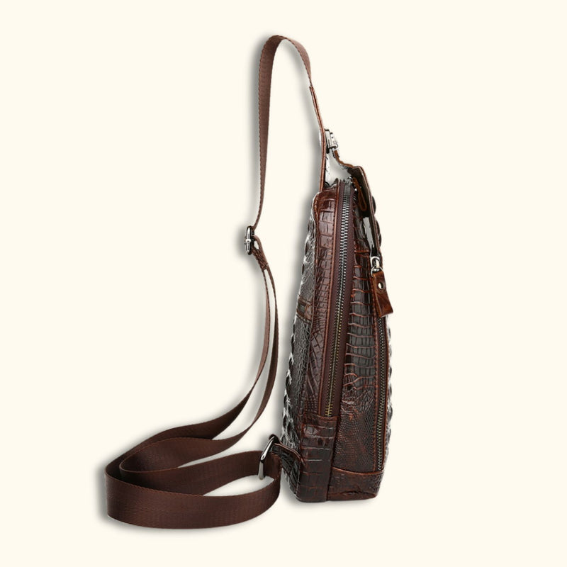 Side view of the Croc Ridge Leather Sling Bag, highlighting the detailed crocodile pattern and the adjustable strap on rich brown leather.