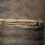 Close-up detail of a distressed leather jacket, showcasing the texture and zipper craftsmanship.