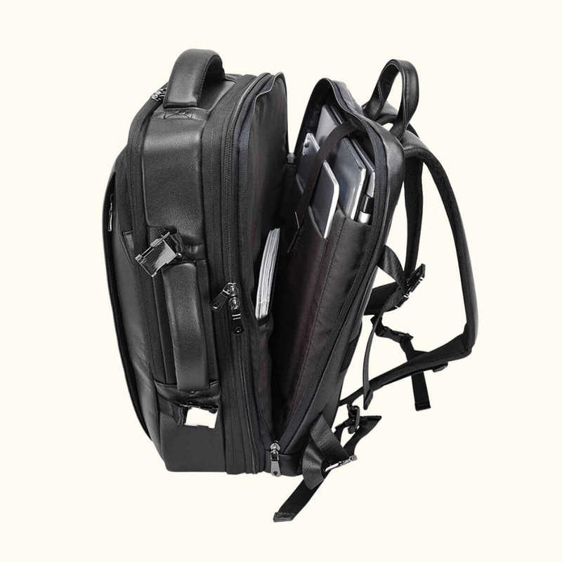 The Stetson Peak - Expandable Men's Leather Backpack in black, open view showing multiple spacious compartments, internal pockets, and secure buckles for organized storage.