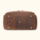 The Homesteader - Western Luxury Leather Duffel Bag, showcasing a high-quality leather bottom view with reinforced brass feet for durability and style.